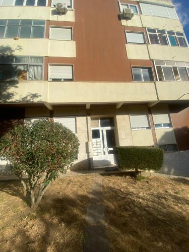 a building with a tree in front of it at Helder&Joana Five Star Holiday in Póvoa de Santa Iria
