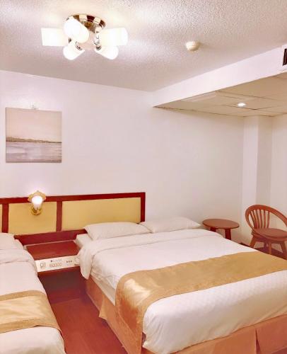 a bedroom with two beds and a ceiling at Inn Sun Hotel in Changhua City