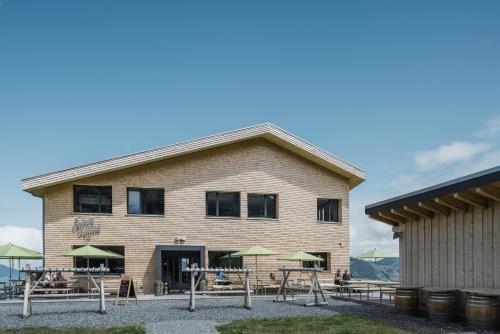 a building with tables and umbrellas in front of it at Stoos Hüttä in Stoos