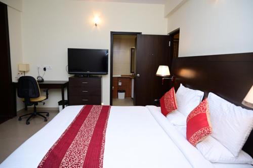 a bedroom with a large bed with red and white pillows at Citrus plaza in Bengaluru