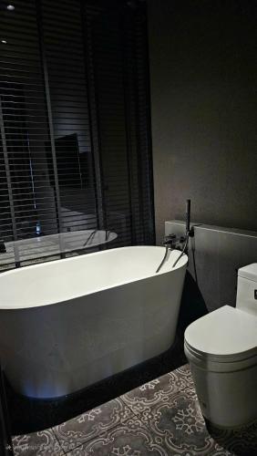 a bathroom with a white tub and a toilet at inchantreemeedao in Ban Chuk Kum