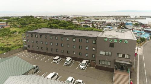 a building with cars parked in a parking lot at サンホテル大間 in Ōma
