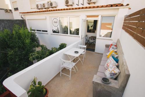 a small balcony with a bench and a table at PTM DownTown Hostel&Suites in Portimão