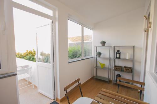 a white room with a table and chairs and windows at PTM DownTown Hostel&Suites in Portimão