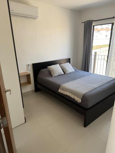 a bedroom with a bed and a window at Take A Break in El Suazal