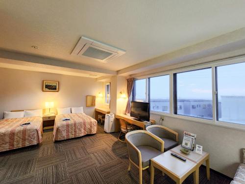 a hotel room with two beds and a television at サンホテル大間 in Ōma