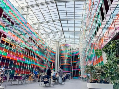 a brightly colored building with people sitting at tables at Hotel Jardines de Uleta Suites in Vitoria-Gasteiz