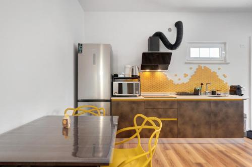 a kitchen with a stainless steel refrigerator and a table at Honey Home With Parking in Laives
