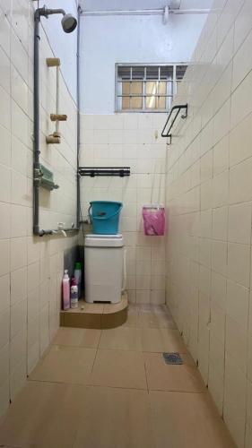a bathroom with a toilet in a tiled room at Malaika Homestay in Alor Setar