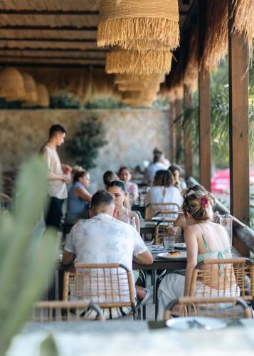 a group of people sitting at tables in a restaurant at Delight Hotel in Ksamil