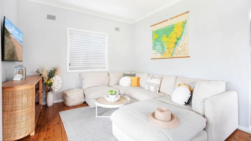 a living room with a white couch and a table at Sandy Paws in Culburra Beach