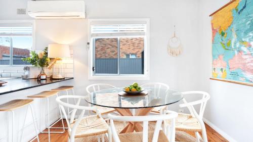 a dining room with a glass table and chairs at Sandy Paws in Culburra Beach