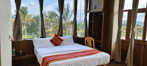 a bed in a room with large windows at CKM- Lake View Mountain View and Pool in Chikmagalūr