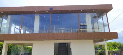 a glass building with a balcony on top of it at CKM- Lake View Mountain View and Pool in Chikmagalūr
