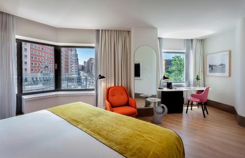 マドリードにあるバルセロ トーレ デ マドリッドのベッド、デスク、椅子が備わるホテルルームです。