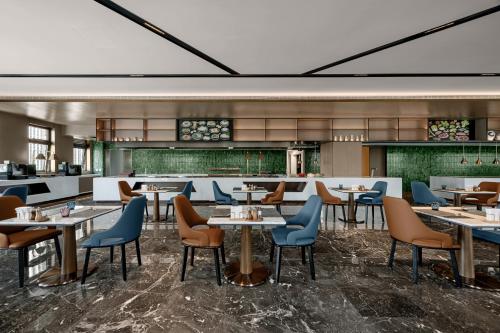 a rendering of a restaurant with tables and chairs at Novotel Kunshan East in Kunshan