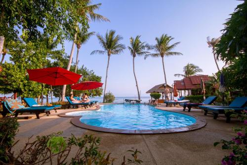 a pool with chairs and umbrellas next to the ocean at Morning Star Resort in Baan Tai