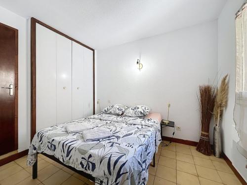 a bedroom with a bed with a blue and white comforter at Le Luxembourg - Appartement proche des Halles - Wifi in Narbonne