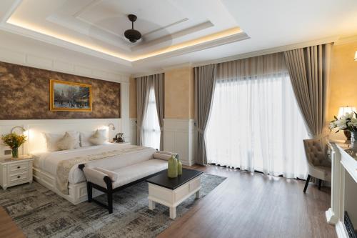 a bedroom with a large white bed and curtains at Anik Palace Hotel in Phnom Penh