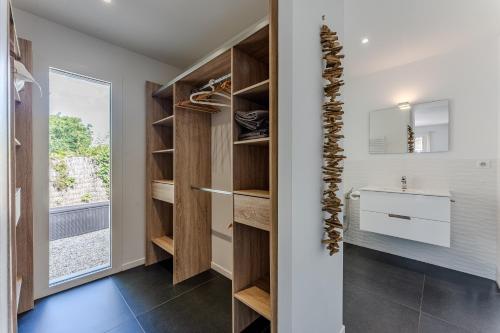 bagno con tavolo da trucco, lavandino e finestra di La villa Sirelis piscine et spa a Gujan-Mestras