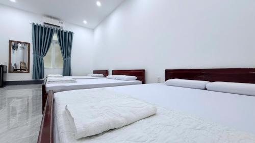 a group of four beds in a room at Hà Tiên Hạnh Phúc Hotel in Ha Tien