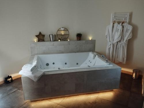 a bathroom with a large tub in a room at Le Mas aux Amoureux , Suite Romantique et Spa in Le Barcarès