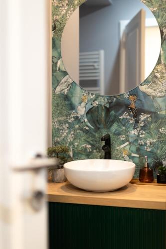 a bathroom with a white sink and a mirror at Nest Inn Emerald Apartment in Baia Mare