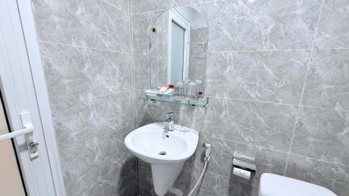 a bathroom with a sink and a mirror at Hà Tiên Hạnh Phúc Hotel in Ha Tien