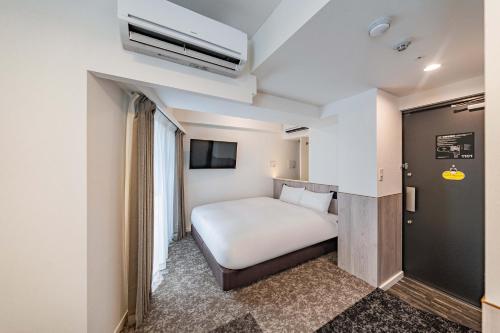 a hotel room with a bed and a tv at Apartment Hotel 11 Asakusa 1 in Tokyo