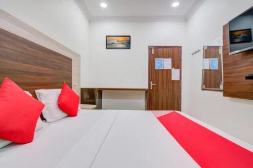 a bedroom with a large white bed with red pillows at HoTEL APPLE GRAND in Vijayawāda