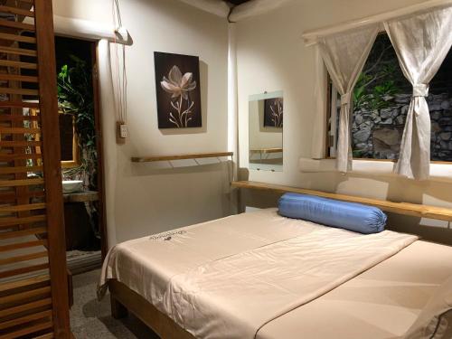 a bedroom with a bed with a blue pillow on it at Đà Lạt in Phú Quốc Homestay - Free Airport Pickup for 4 night bookings in Phu Quoc