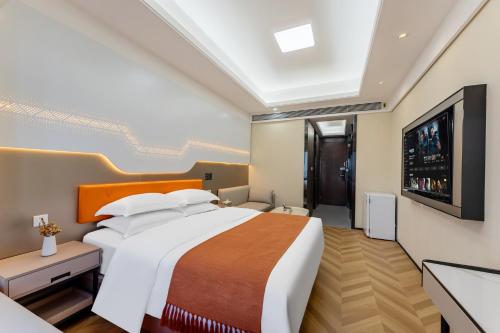 a bedroom with a large bed and a flat screen tv at X-Star Designer hotel Convention and Exhibition Center Branch in Guangzhou
