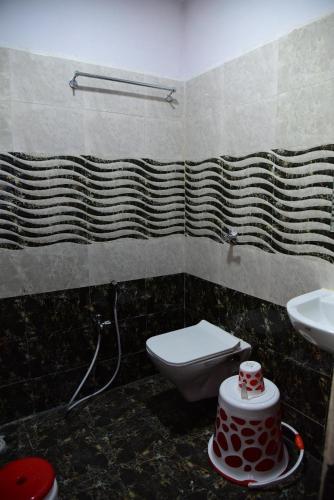 a bathroom with a toilet and a sink at HoTEL APPLE GRAND in Vijayawāda