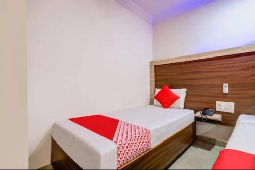 a bedroom with a bed with red pillows at HoTEL APPLE GRAND in Vijayawāda