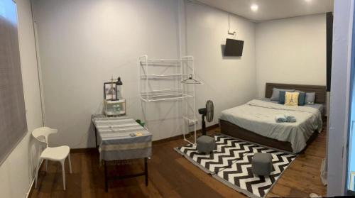 a bedroom with a bed and a table and a chair at Cat in the box homestay in Godown