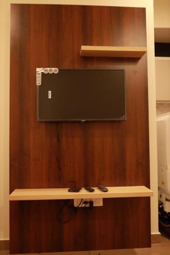 a flat screen tv on a wooden wall at Grace Apart Hotel @Kochi in Cochin