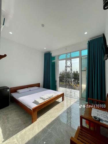 a bedroom with a bed and green curtains at Hà Tiên Hạnh Phúc Hotel in Ha Tien