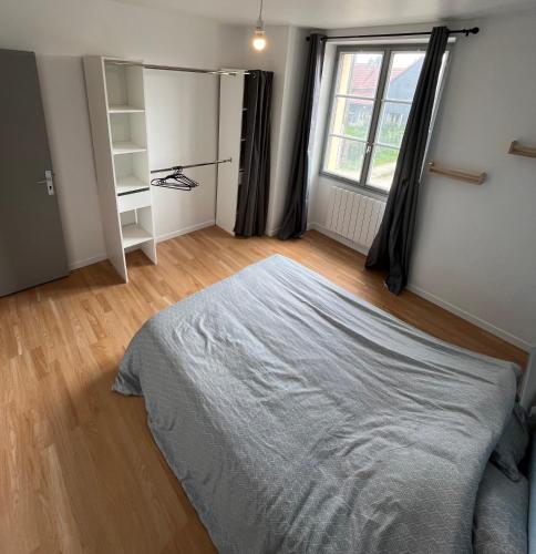 a bedroom with a bed and a large window at La petite maison de Chéu in Chéu