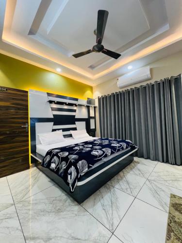 a bedroom with a bed and a ceiling fan at Hotel River View Panipat in Pānīpat