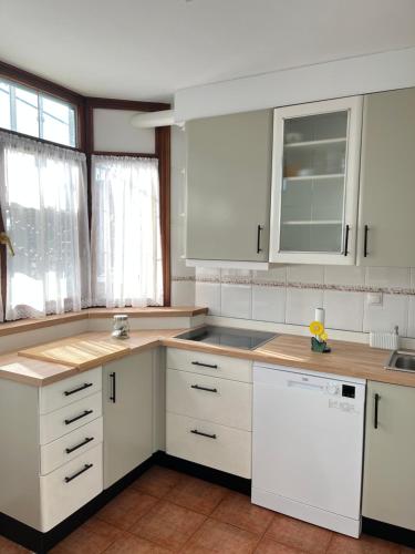 a kitchen with white cabinets and white appliances at El Rincón de la Playa in Mogro