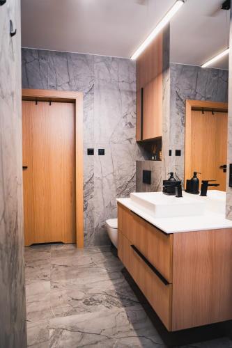 a bathroom with a sink and a toilet at Wzgórze Wichrów Resort 