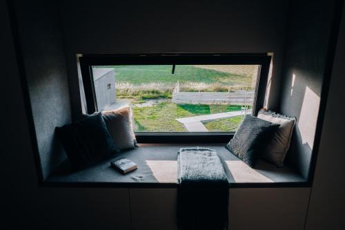 a window seat in a room with a book at Wzgórze Wichrów Resort 