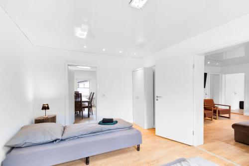 a white bedroom with a bed and a living room at 24-7 Living - Unna Central City Apartments in Unna