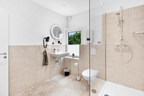a bathroom with a shower and a sink and a toilet at 24-7 Living - Unna Central City Apartments in Unna