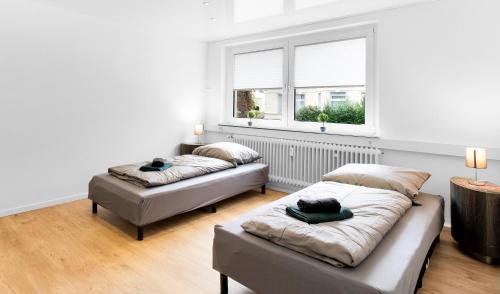 a bedroom with two beds and a window at 24-7 Living - Unna Central City Apartments in Unna
