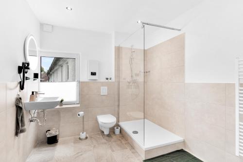 a bathroom with a shower and a toilet and a sink at 24-7 Living - Unna Central City Apartments in Unna