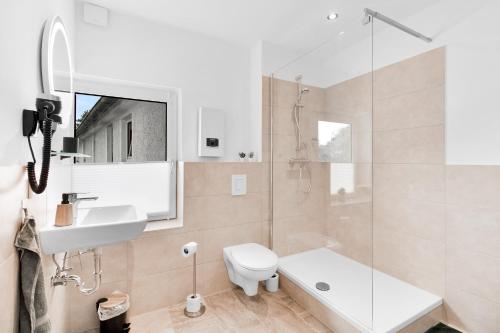 a bathroom with a sink and a toilet and a shower at 24-7 Living - Unna Central City Apartments in Unna