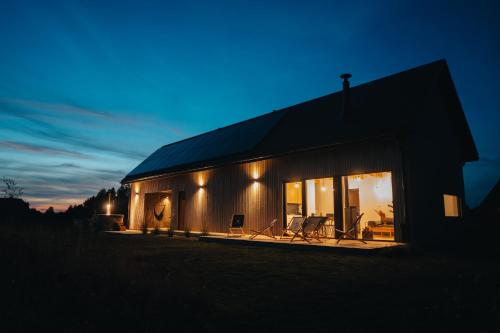 a house with a dark roof at night at Wzgórze Wichrów Resort 