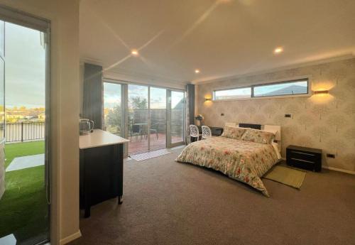 Un dormitorio con una cama y una ventana grande. en Lake view, private access room & private Bathroom, en Hamilton