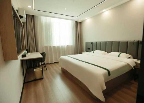 a hotel room with a large bed and a desk at GreenTree Inn Langfang Sanhe South Yingbin Road Express Hotel in Sanhe